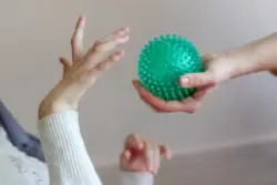 child with cerebral palsy doing mobility exercises with ball