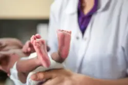 Female pediatrician holding a newborn