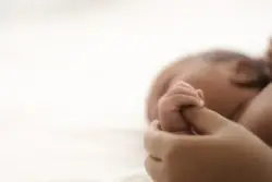 mother holding hand of newborn child
