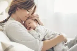 mom holds sleeping baby
