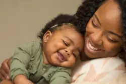 woman and baby daughter smiling together