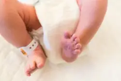 An infant’s feet with a hospital tag.