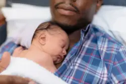 A father holds his infant in the hospital.