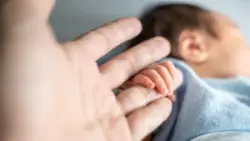 newborn grasps its parent’s finger