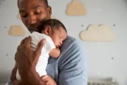father holds newborn baby