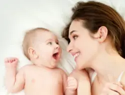 mother and baby smile at each other while lying down