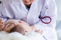 pediatrician examines sick newborn