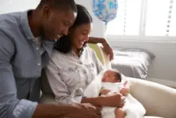 mother and father hold newborn in hospital room
