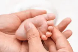 mother holding baby foot