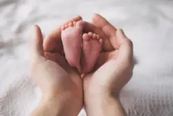 mother holding newborn’s feet