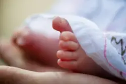 parent holding baby’s feet covered in blanket