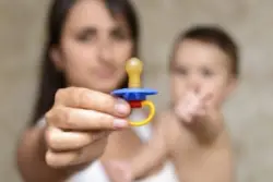 Mother Shows Pacifier For The Baby