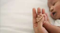 An Ohio cerebral palsy lawyer holds the hand of a baby with cerebral palsy.
