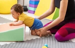 Woman checking baby for spastic diplegic cerebral palsy symptoms