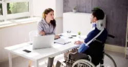 A severely injured accident victim in a wheelchair talks to a Cincinnati personal injury lawyer.