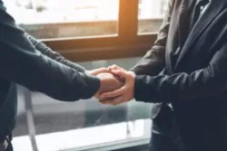 A Cincinnati wrongful death lawyer shakes hands with a client who recently lost a family member in a fatal car accident.