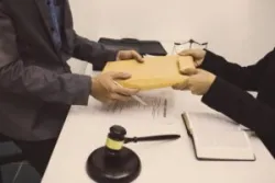 A person hands evidence to a lawyer to prove police brutality.