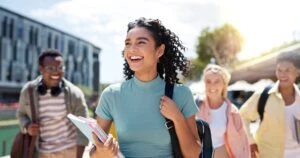 Happy students navigate a college campus free of hazing. How do state hazing laws vary?