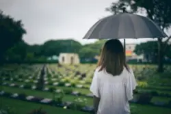 woman holding umbrella at a cemetary