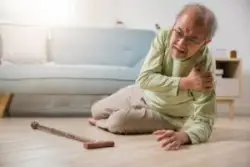 older man on floor with cane