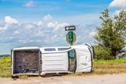 overturned white pickup in a ditch