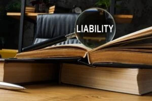 A magnifying glass on top of a book, looking at the word “liability.” How is negligence proven in a premises liability claim?