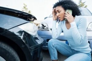 A woman on the phone with her insurance company after a car accident, wondering what to do if the insurance company is stalling her claim.