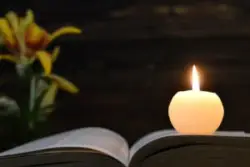 A candle, book, and flower memorialize a wrongful death victim