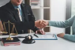 a male truck accident lawyer shaking hands with a female client