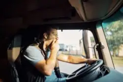 a fatigued Norwich truck driver yawning while driving a commercial vehicle