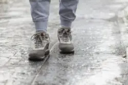 A man walking along a frozen path. You can contact an Enfield slip-and-fall accident lawyer after sustaining an injury.