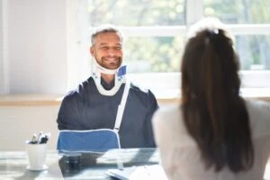 Man in neck brace and arm sling meets with Sioux Falls truck accident lawyer