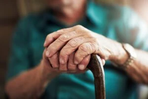 An older man holds a cane while learning what Supplemental Security Income is during a consultation with his attorney. A disability lawyer can explain SSI benefits and appeal a denied claim.