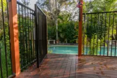 A fence with an open gate around a home swimming pool. Contact a Miramar Beach swimming pool accident lawyer if you were injured while swimming.