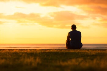 A man sitting outdoors and considering a Jacksonville fatal car accident lawyer.