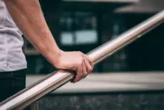 man-holding-onto-a-faulty-handrail