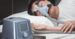 man sleeping with CPAP machine