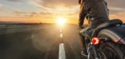 Motorcycle driver riding alone on asphalt motorway. Outdoor photography.