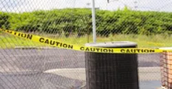 caution tape surrounding fence at a park