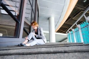 a hurt woman holding her ankle wondering the difference between premises liability and personal liability.