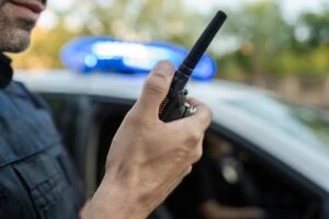 A police officer talking on his walkie-talkie. Can you change a police report after a car accident?