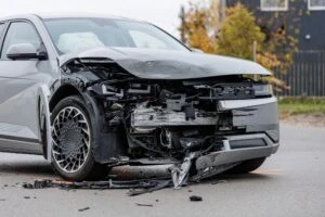A smashed front end of a car after a car accident. Who pays for medical bills?