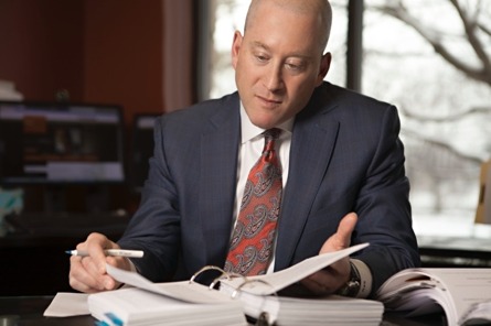 David sits at his desk looking through a notebook