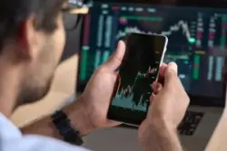 A stockbroker at their computer selling a client’s stocks without permission.