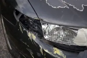 black sedan with damage from a side-swipe accident