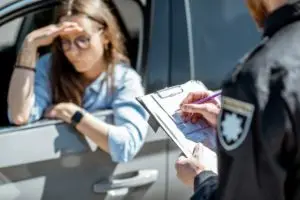 cop writing woman a traffic ticket
