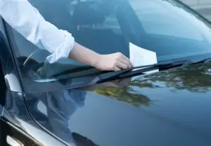 guy pulling a traffic ticket off his car