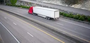 red big-rig driving down the road