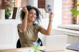 woman celebrating good news at her computer