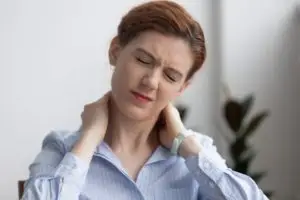 woman rubbing her neck in pain